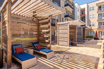 A wooden patio with a blue cushioned chair and a table.